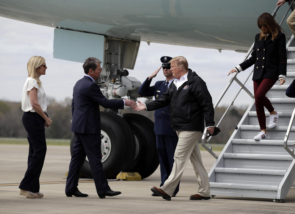 President Donald Trump, with first lady Melania Trump, is greeted by Georgia Gov. Brian Kemp and his wife Marty, as they arrive on Air Force One at Lawson Army Airfield, Fort Benning, Ga., Friday, March 8, 2019.