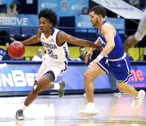 Georgia State guard Kane Williams (12) drives past Texas-Arlington guard DJ Bryant (2) during the second half of the NCAA college basketball championship game of the Sun Belt Conference men's tournament in New Orleans, Sunday, March 17, 2019.