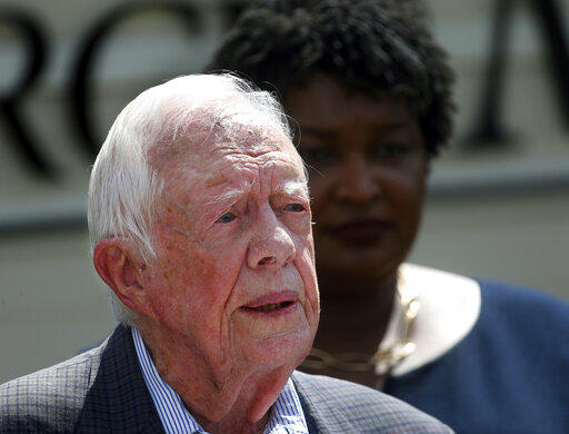 In this Sept. 18, 2018 file photo, former President Jimmy Carter speaks as Democratic gubernatorial candidate Stacey Abrams listens during a news conference to announce her rural health care plan, in Plains, Ga. Carter is now the longest-living president 