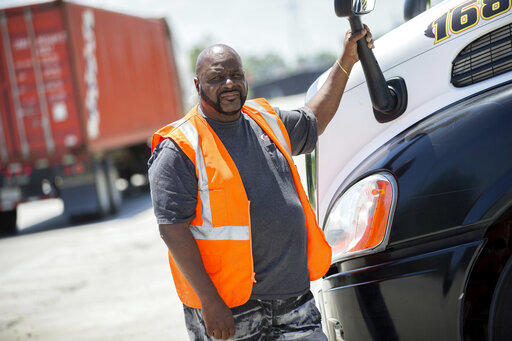 Leon Brown stands by his tractor-trailer after making a delivery from a distribution center to the Port of Savannah, in Garden City. 
