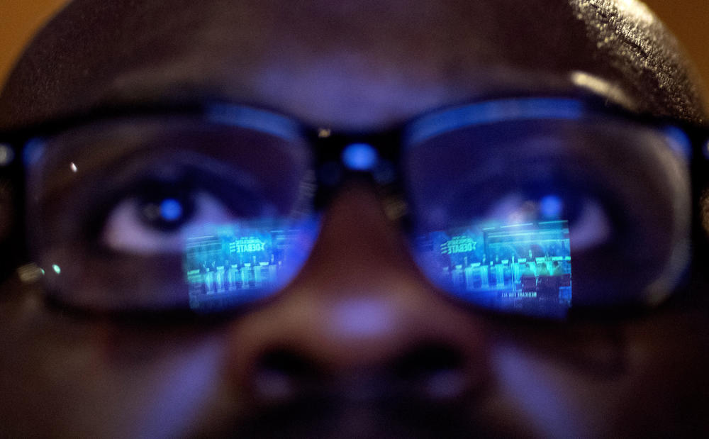 Offei Koram watches a broadcast of a Democratic presidential debate at a bar in Atlanta on Thursday, June 27, 2019.