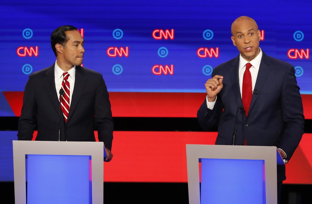 Former Housing and Urban Development Secretary Julian Castro listens as Sen. Cory Booker, D-N.J., speaks during the second of two Democratic presidential primary debates hosted by CNN Wednesday, July 31, 2019, in the Fox Theatre in Detroit. 