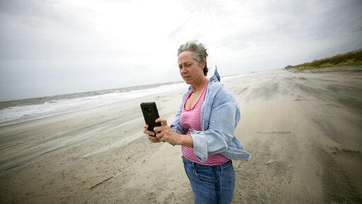 Crystal Travaille takes a cell phone photo of the wind and seas on the beach as Hurricane Dorian makes its way up the east coast, Wednesday, Sept. 4, 2019, in Tybee Island.