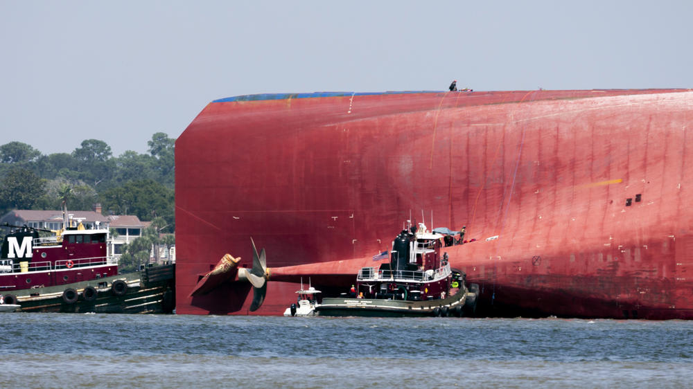 Rescuers work near the stern of the vessel Golden Ray as it lays on its side near the Moran tug boat Dorothy Moran, Monday, Sept. 9, 2019, in Jekyll Island, Ga.