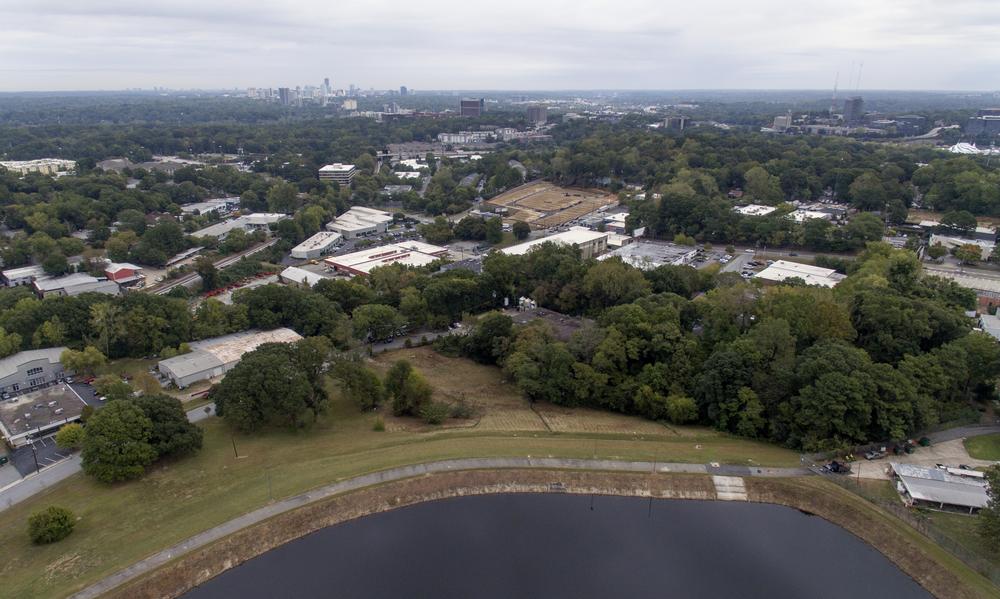 Homes and businesses sit downhill from Reservoir No. 1, a 180 million gallon water supply that has been out-of-service much of the past few decades, Tuesday, Oct. 15, 2019, in Atlanta. The city made repairs and brought it back online in 2017, only to shut