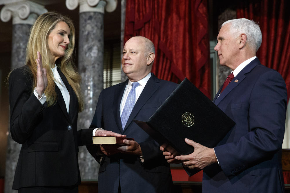 Sen. Kelly Loeffler, R-Ga., left, with her husband Jeffrey Sprecher, center, participates in a re-enactment of her swearing-in Monday Jan. 6, 2020, by Vice President Mike Pence in the Old Senate Chamber on Capitol Hill in Washington.