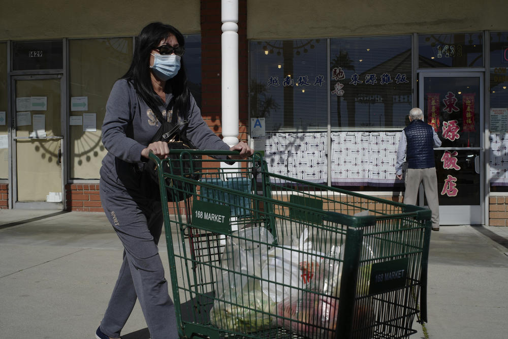 Tien Ngyuen wears a mask as she shops at the 168 Market in Alhambra, Calif., Friday, Jan. 31, 2020.