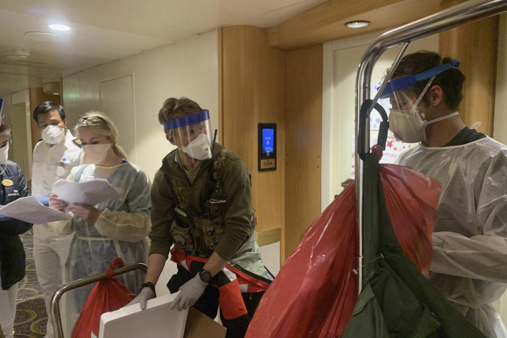 A group of medical personnel working alongside individuals from the Centers for Disease Control and Prevention, don protective equipment after delivering virus testing kits to the Grand Princess cruise ship off the coast of California.