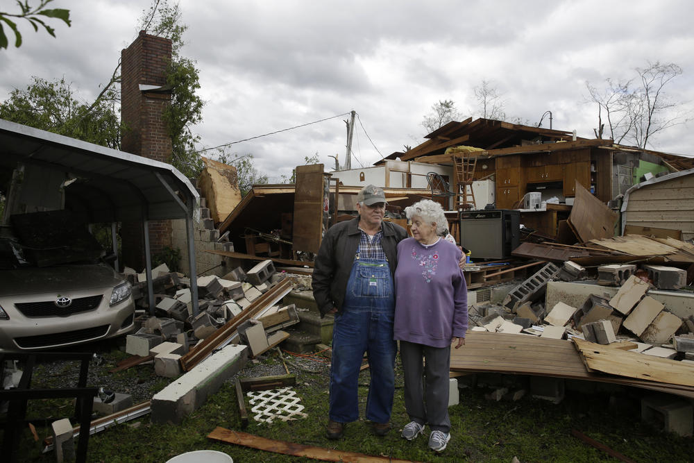Emma, 78, right, and husband Charles Pritchett, 80, stand in front of their home the day after a tornado hit, Monday, April 13, 2020, in Chatsworth, Ga. 
