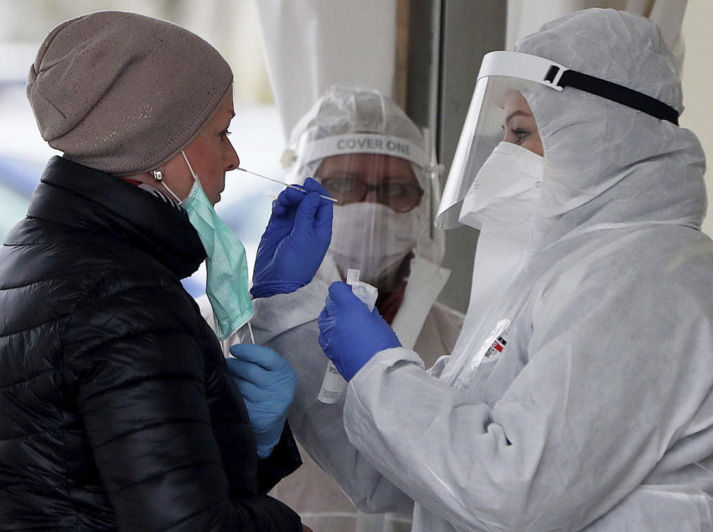 Employee of a private medical firm takes a coronavirus test sample from a health care employee in an action organized in one of Warsaw's districts to help diagnose the spread of the virus, in Warsaw, Poland, Wednesday, April 15, 2020. 