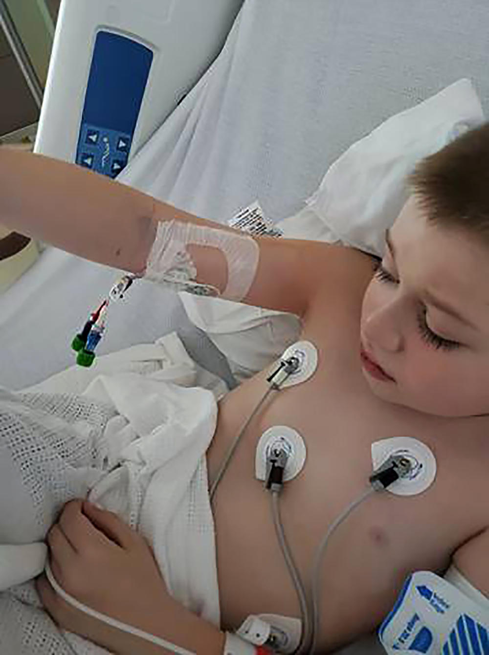Bobby Dean lies in a hospital bed in Rochester, N.Y., after being admitted with severe dehydration, abdominal pain and a racing heart. He tested positive for coronavirus at the hospital and the doctors diagnosed him with a pediatric inflammatory syndrome.