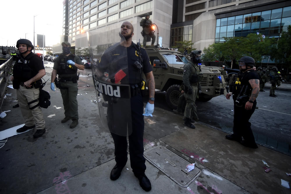 An Atlanta Police Officer stands near where police officers and protesters clashed near CNN center, Friday, May 29, 2020 in Atlanta. The protest started peacefully earlier in the day before demonstrators clashed with police.