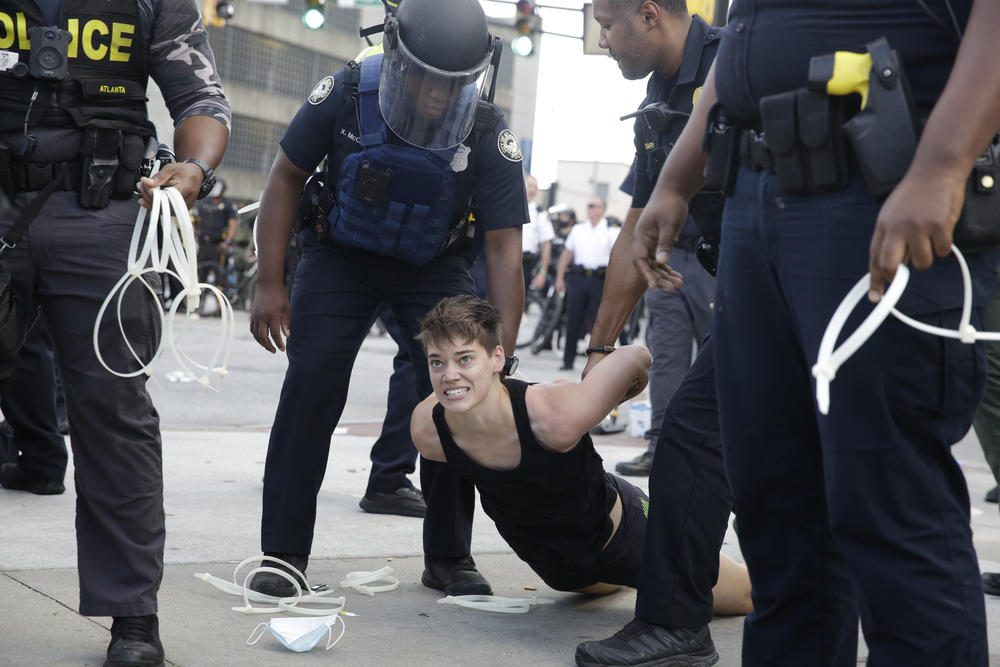 A demonstrator is detained by Atlanta Police during a protest, Saturday, May 30, 2020 in Atlanta. The protest started peacefully earlier in the day before demonstrators clashed with police.
