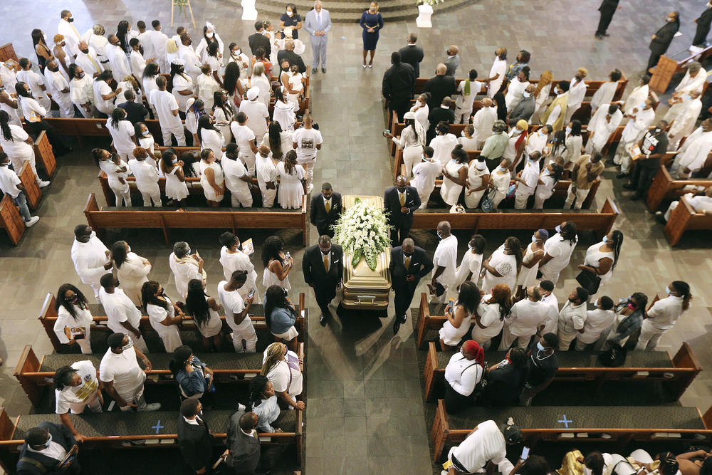 Family members dressed in while stand in respect as the body of Rayshard Brooks is carried out during his funeral in Ebenezer Baptist Church on Tuesday, June 23, 2020 in Atlanta. 