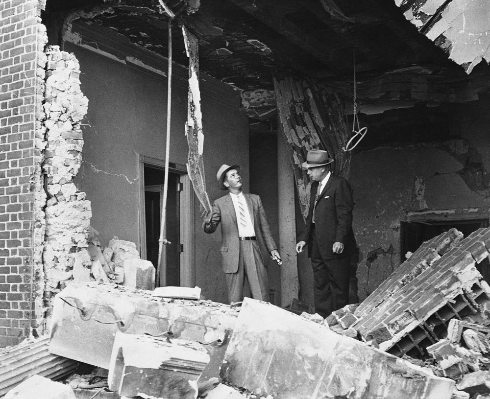 Det. Supt. I. G. Cowan, right, and Det. W. K. Perry examine dynamite ruins after an explosion at a Jewish temple in Atlanta on Oct. 13, 1958. No one was injured.