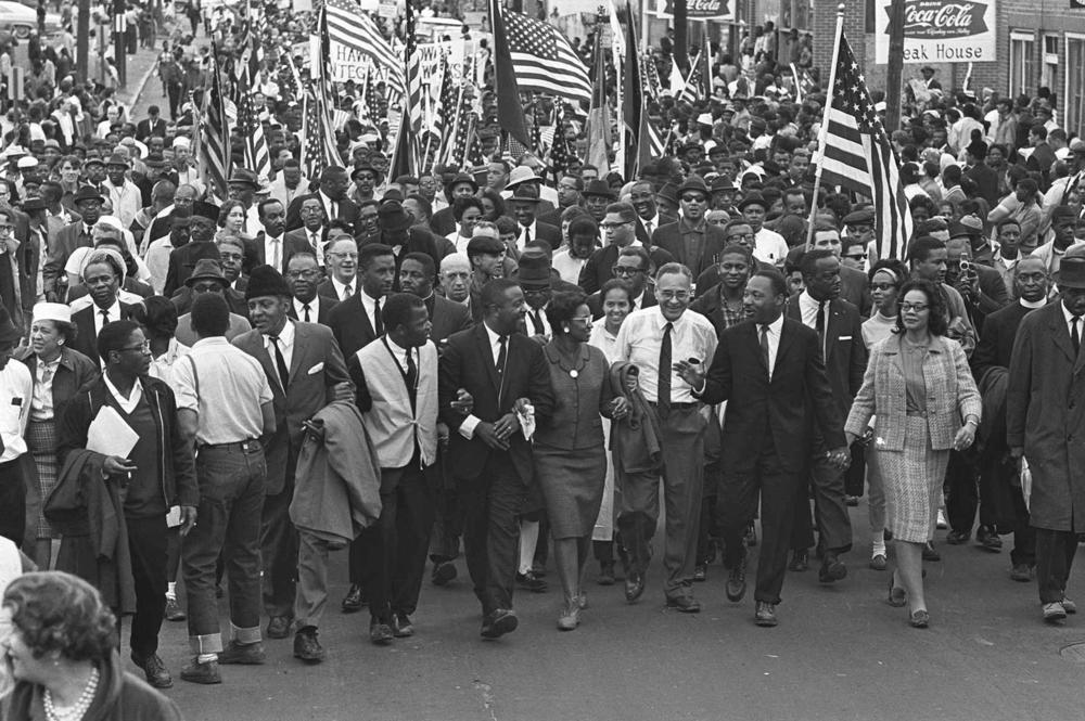 Dr. Martin Luther King Jr. and fellow civil rights activists march across the Alabama River on the first of a five-day, 50-mile march to the state capitol at Montgomery, Alabama, on March 21, 1965.