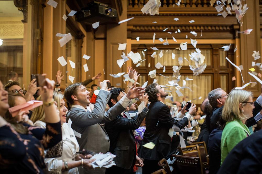 Georgia House members throw up papers at the conclusion of the legislative session in the House Chamber.