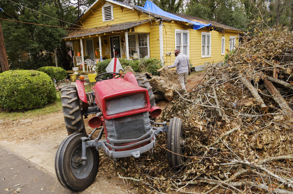 Bobby Washington his tractor to drag a piece of  oak tree downed by Hurricane Michael out of a neighbor's yard in Bainbridge. Over two weeks after the storm barreled into southwest Georgia, power is still out in some neighborhoods and children have just b