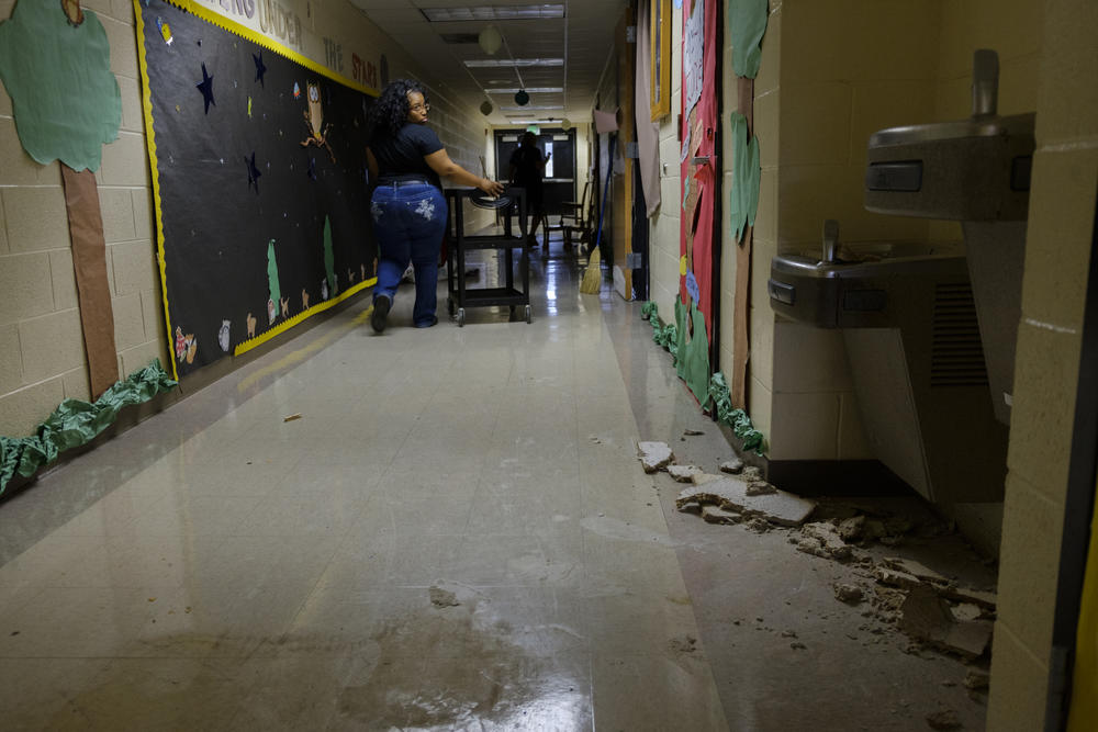 Pre-kindergarten teacher Jessica Beard looks back at some of the damage made by Hurricane Michael to the hall where she has her class at Potter Street.