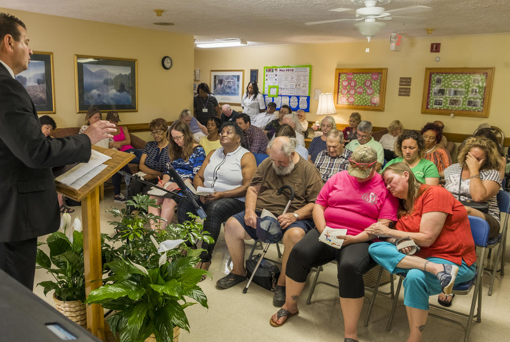 Relatives of deceased residents of the Gray Health And Rehabilitation assisted living home in Gray pray together near the end of the annual bereavement ceremony at the facility on May 14. 
