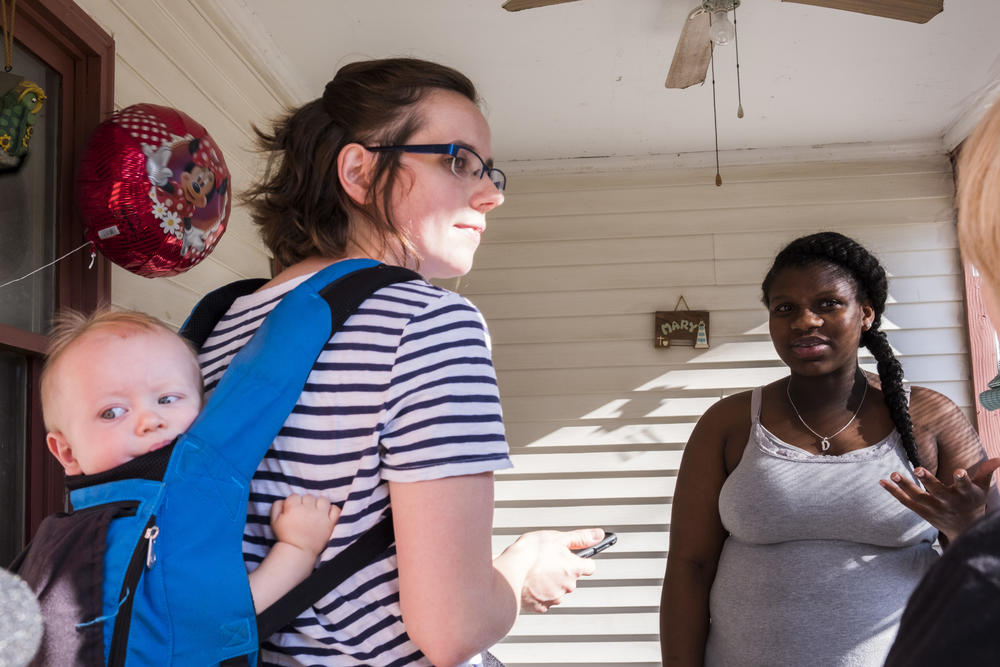 Cheyenne Warnock, left, candidate for a Georgia House of Representatives seat talks with Deandrea Baker on the porch of her Cochran home during Warnock's first day of door to door canvassing. 