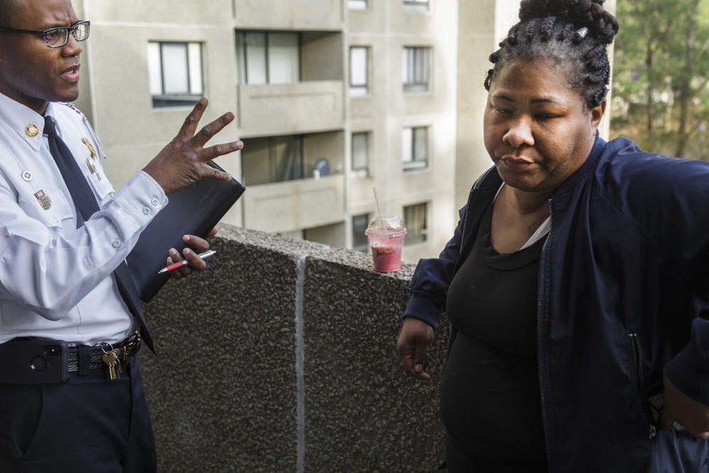 Angelia Starks, right, reacts to news that she and her neighbors have to evacuate their homes at Crystal Lake Apartments due to rafts of safety code violations in February.