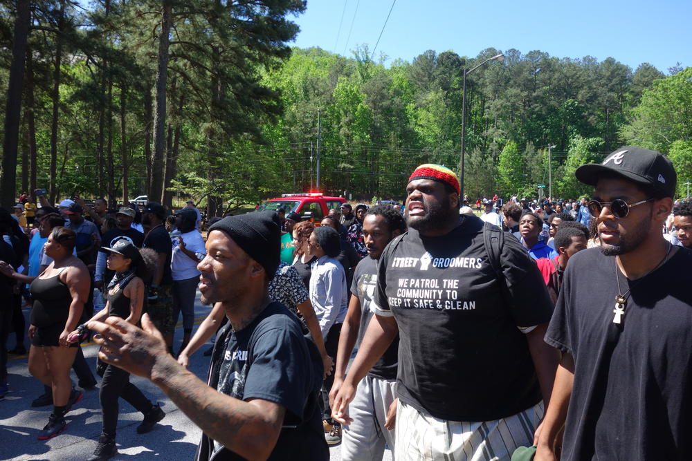 A crowd of Black Lives MAtter protestors moves into the west entrance of the park.