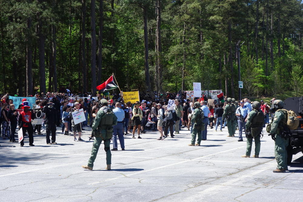 Counter-protesters gather across the parking lot from the Confederate rally.