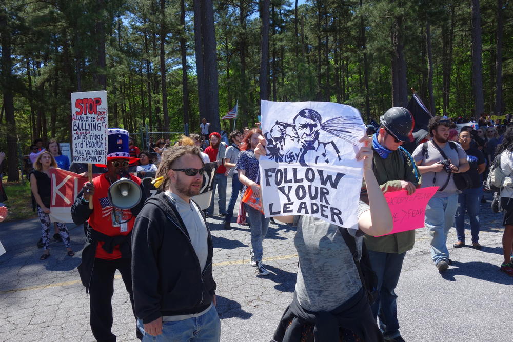 Protestors hold up signs in front of the police.