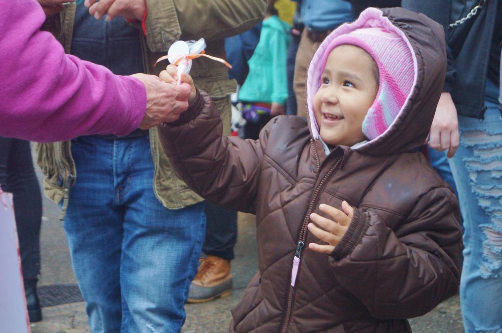 A girl received candy from a parade participant.