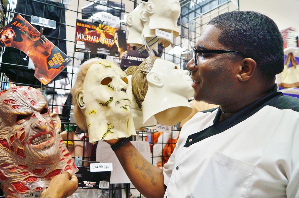 Two men looked at Halloween masks.