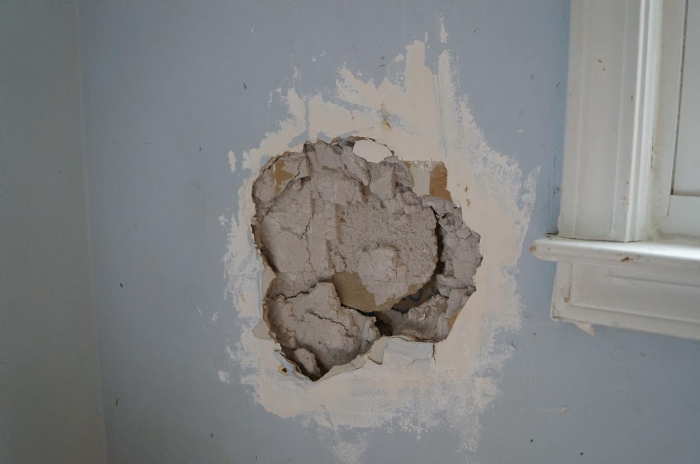 A volleyball-sized hole near Johnathan's bedroom window from when he kicked in the wall.