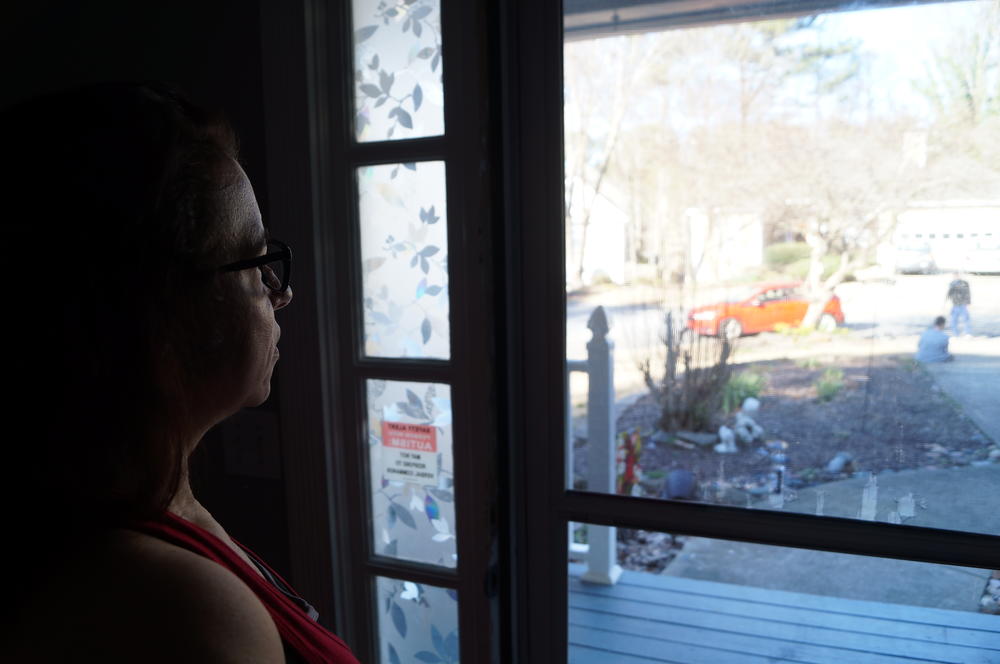 Elizabeth Sherwood watches her son Johnathan play outside with his therapist Marco Perez.