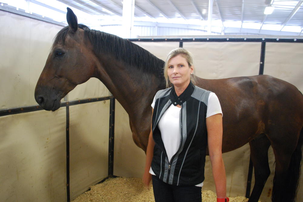 Paige May, of Richmond Hill, Georgia,  soothes her horse Fab.