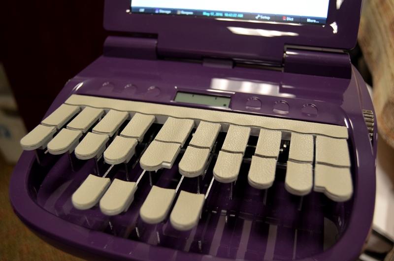 Evelyn's stenograph has only 14 keys, a number bar, and vowels. The keys are unmarked so she memorized the keys. She doesn't type letters but the syllables and sounds of the words. 