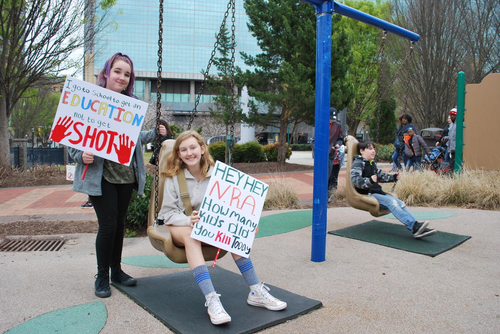 Aila Cason and Sofia Baeszler stop for a swing on the way to the march. 