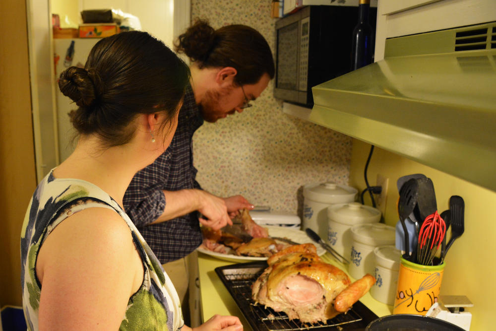 Sam Bradford carving the Friendsgiving turkey under the watchful eye of Valerie Bradford.