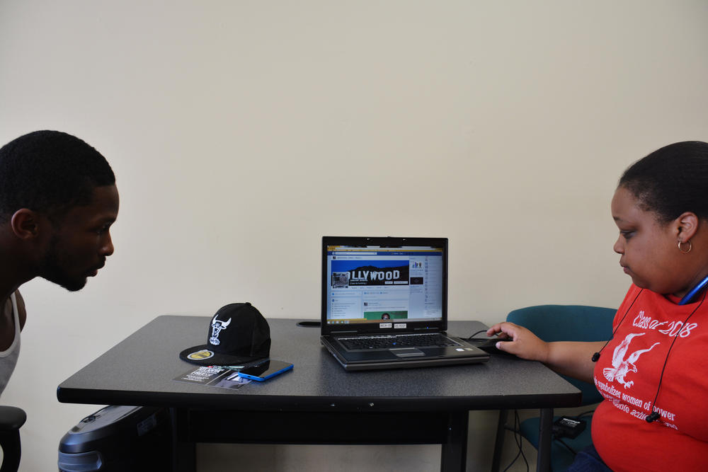 Jaferrel Jenkins shows off his Facebook page with the help of one of the lab's volunteers, a student from nearby Spelman College.