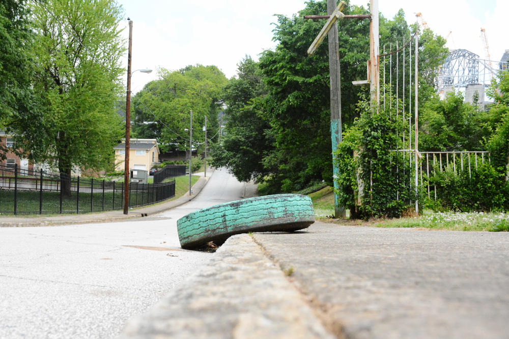 The view up Rhodes Street in Vine City toward downtown Atlanta. Mercedes Benz Stadium rises in the background.