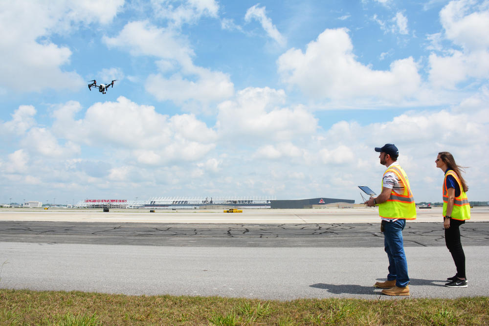 Jim Duguay and Katie Eleam pilot a drone over runway 27R at Hartsfield-Jackson Atlanta International Airport.