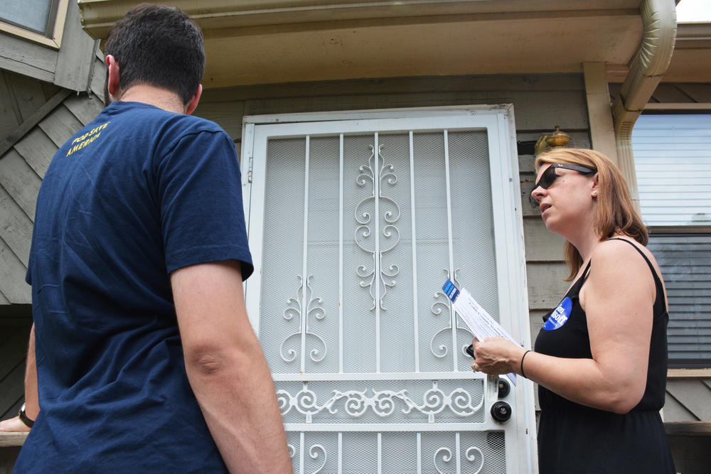 Georgette Dobkin and her son, Jack, wait to see if anyone's home as they canvass for the Ossoff campaign in Cobb County. Dobkin co-founded GA 6th Youth Got This with other moms in the 6th District.