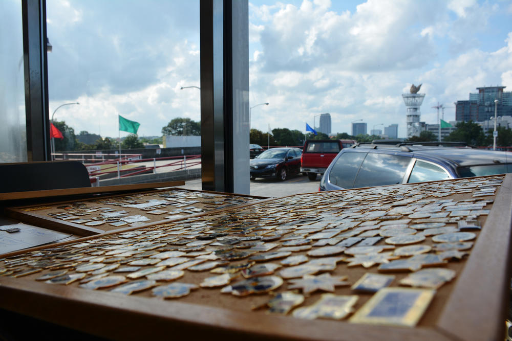 The Olympic Torch Tower still rises over Midtown Atlanta where, 20 years on, pin trading continues. 