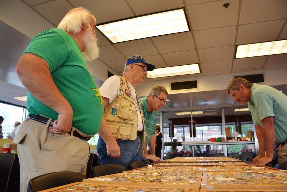 Randy Parsons (front) speaks with other Olympic pin traders at the monthly pin show in Atlanta. The event has been happening at the Varsity drive-in since the 1996 Olympics. 