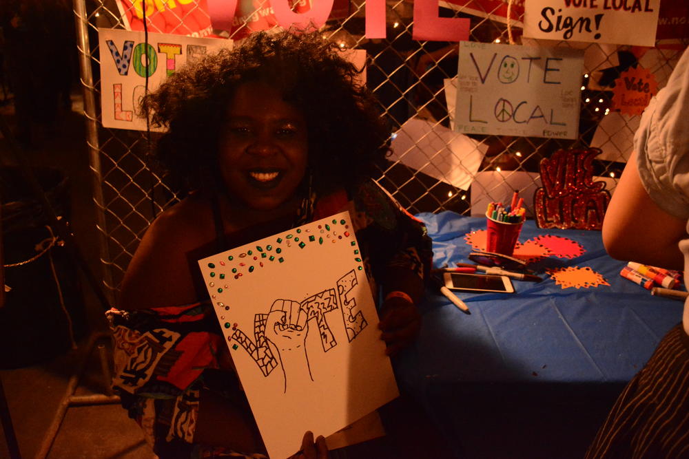 AfroPunk attende Cayana Mackey of Atlanta holds up a poster she made to show her support for voting. 