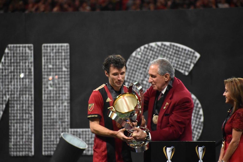 Team captain Michael Parkhurst and owner Arthur Blank hold the MLS Cup