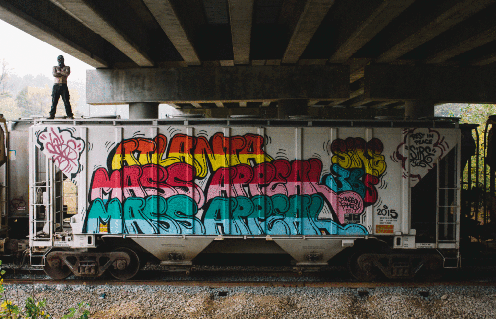 Dr. Dax stands atop a freight car decorated with his work.