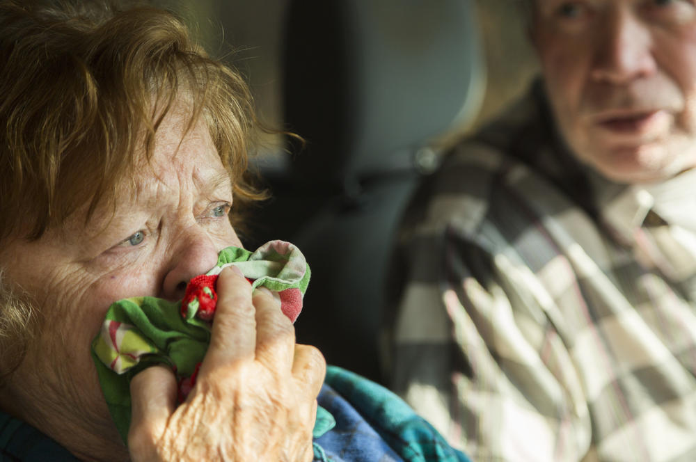 Judy Macabee uses a wet dish towel to filter out smoke from a fire on Ryo Mountain in Gordon County, Georgia while she and her husband Max talk with an official from the Georgia Forestry Commission. 