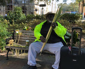 James Pringle weaves reed roses in Wright Square.