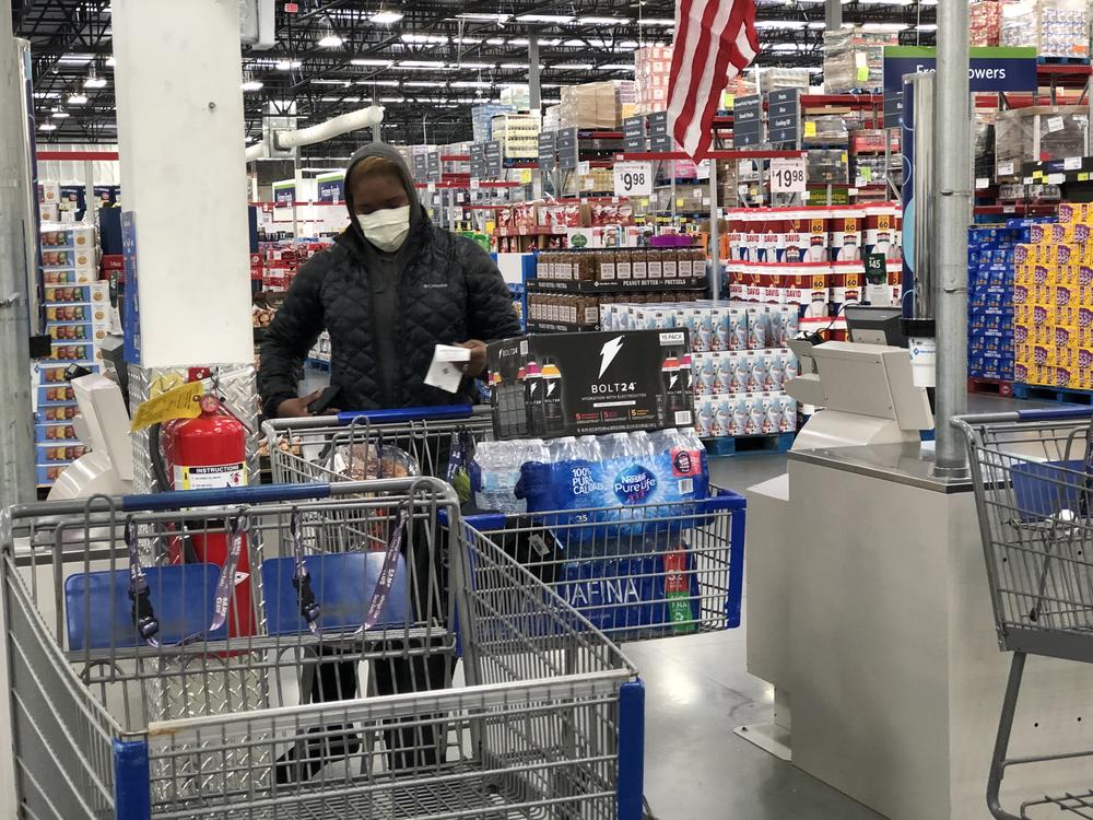 A shopper wears a face mask while buying cases of water at a Sam's Club in Woodstock Wednesday, March 4, 2020.