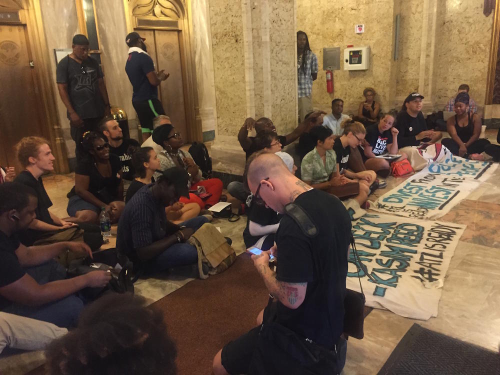 Protestors not allowed into the closed meeting with Mayor Kasim Reed chanted and sang in the lobby of Atlanta City Hall. 